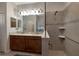 Bright bathroom features a double vanity, large mirror, and walk-in shower with neutral tile and glass surround at 3710 Plymouth Dr, Winter Haven, FL 33884