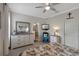 Bright bedroom features tile floors, a ceiling fan, dresser, TV, and attached bathroom at 3710 Plymouth Dr, Winter Haven, FL 33884