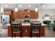 Modern kitchen features an island with seating, stainless appliances, and warm wood cabinets at 3710 Plymouth Dr, Winter Haven, FL 33884
