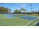 Outdoor tennis courts featuring a blue and green playing surface and surrounding trees for shade at 3710 Plymouth Dr, Winter Haven, FL 33884