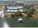 Aerial view of the community pool, clubhouse, tennis courts, and pier extending into the lake at 3912 Baldwin Ln, Winter Haven, FL 33884