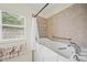 Walk-in tub features safety grab bars, a showerhead, and a glass door for easy and safe access at 3912 Baldwin Ln, Winter Haven, FL 33884