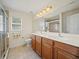 Bathroom with a double vanity, large mirror, and tiled shower, providing ample space and modern amenities at 3912 Baldwin Ln, Winter Haven, FL 33884