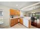 Bright eat-in kitchen featuring wooden cabinets, a stainless steel sink and a white dishwasher at 3912 Baldwin Ln, Winter Haven, FL 33884