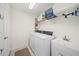 Functional laundry room featuring a washer, dryer, storage shelves, and a utility sink at 3912 Baldwin Ln, Winter Haven, FL 33884