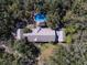 A beautiful house with pool and tiki hut nestled among lush trees, offering a private retreat at 4010 Paw Paw Trl, Lake Wales, FL 33898