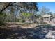 Exterior backyard shot shows the outdoor living areas, deck, mature trees, and native landscaping at 4010 Paw Paw Trl, Lake Wales, FL 33898