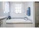 Bright bathroom featuring a standalone tub with tile surround and a shower to the right at 4010 Paw Paw Trl, Lake Wales, FL 33898