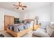 Bright bedroom with a wooden bed frame, dresser, and a comfortable accent chair, creating a cozy retreat at 4010 Paw Paw Trl, Lake Wales, FL 33898