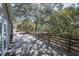Expansive wooden deck off the home, with mature shade trees, providing an inviting outdoor living space at 4010 Paw Paw Trl, Lake Wales, FL 33898