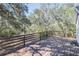 Exterior image shows a large wooden deck with wooden railing and shade from mature trees at 4010 Paw Paw Trl, Lake Wales, FL 33898