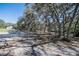 Wide front yard with verdant trees and ample parking space, enhancing the property's curb appeal at 4010 Paw Paw Trl, Lake Wales, FL 33898