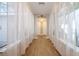 Hallway with hardwood floors and many windows and white curtains at 4010 Paw Paw Trl, Lake Wales, FL 33898