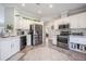 Modern kitchen features stainless steel appliances, white cabinets, granite countertops, and ample storage space at 4010 Paw Paw Trl, Lake Wales, FL 33898