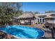 Backyard featuring a sparkling pool, tiki hut, outdoor seating, and fenced yard, perfect for relaxation and enjoyment at 4010 Paw Paw Trl, Lake Wales, FL 33898
