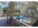 Outdoor pool area features a wooden deck, Tiki hut, and lounge seating, perfect for relaxing in a tropical setting at 4010 Paw Paw Trl, Lake Wales, FL 33898