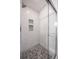 Glass shower with white tile walls and stone tile floor with built in shelves at 4010 Paw Paw Trl, Lake Wales, FL 33898