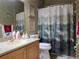 Bathroom with wood cabinet, grey countertop, framed prints, and shower with nature themed curtain at 4063 Birkdale Dr, Lake Wales, FL 33859