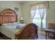 Bedroom featuring a wooden framed bed with decorative headboard and neutral colored window treatments at 4063 Birkdale Dr, Lake Wales, FL 33859