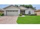 Charming single-story home featuring a well-maintained lawn and a brick-paved driveway leading to a two-car garage at 4063 Birkdale Dr, Lake Wales, FL 33859