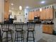 Well-lit kitchen features bar seating, wooden cabinets, and black countertops at 4063 Birkdale Dr, Lake Wales, FL 33859