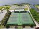 Overhead view of well-maintained tennis courts with fencing, lights and landscaping at 4063 Birkdale Dr, Lake Wales, FL 33859