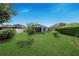 A backyard featuring a well-manicured lawn with trees and shrubs, and a screened in lanai at 4099 Island Lakes Dr, Winter Haven, FL 33881