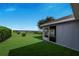 Backyard view featuring a screened in lanai and a well manicured lawn with a waterfront view at 4099 Island Lakes Dr, Winter Haven, FL 33881