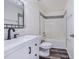 Clean bathroom features a white vanity, dark hardware, a tub with shower, and gray flooring at 4099 Island Lakes Dr, Winter Haven, FL 33881