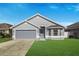 Charming one-story home boasts a well-maintained lawn and a two car garage with a gray exterior paint at 4099 Island Lakes Dr, Winter Haven, FL 33881