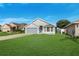 Charming one-story home boasts a well-maintained lawn and a two car garage with a gray exterior paint at 4099 Island Lakes Dr, Winter Haven, FL 33881