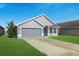 Charming one-story home boasts a well-maintained lawn and a two car garage with a gray exterior paint at 4099 Island Lakes Dr, Winter Haven, FL 33881