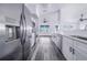 The bright kitchen includes stainless appliances, white cabinetry, gray flooring, and a view of the outside at 4099 Island Lakes Dr, Winter Haven, FL 33881