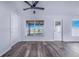 Living room features stylish wood-look flooring, a ceiling fan, and access to the screened-in patio at 4099 Island Lakes Dr, Winter Haven, FL 33881