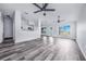 Open-concept living room with gray flooring, lots of light, ceiling fans and a glimpse of the kitchen at 4099 Island Lakes Dr, Winter Haven, FL 33881
