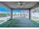 Screened-in patio with artificial turf floor and view of the backyard, perfect for outdoor relaxation at 4099 Island Lakes Dr, Winter Haven, FL 33881