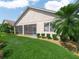 Well-manicured backyard featuring lush green grass, palm trees, and a screened-in patio at 4313 Heath Land Ln, Lake Wales, FL 33859