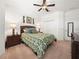 Bedroom with ceiling fan, closet, leaf patterned bedding, and coordinating nightstands with lamps at 4313 Heath Land Ln, Lake Wales, FL 33859