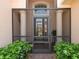 Inviting front entrance with a screened-in porch, stone pillars, and double glass doors at 4313 Heath Land Ln, Lake Wales, FL 33859