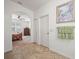 Hallway with beige tile flooring leads to the bedroom with a ceiling fan and arched entry at 4313 Heath Land Ln, Lake Wales, FL 33859