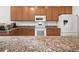 Bright kitchen with white appliances, granite countertops, and plenty of cabinet space at 4313 Heath Land Ln, Lake Wales, FL 33859