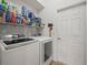 The laundry room contains a newer model washer and dryer, and wire shelving for storage at 4313 Heath Land Ln, Lake Wales, FL 33859