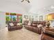 Relaxing living room featuring leather sofas, a large sliding glass door and tile flooring at 4313 Heath Land Ln, Lake Wales, FL 33859