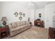 A living room with a sofa, tile floors, and a ceiling fan, creating a cozy and inviting space at 4313 Heath Land Ln, Lake Wales, FL 33859