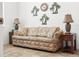 Living room with a large couch, two end tables, and decorative palm tree art pieces on the wall at 4313 Heath Land Ln, Lake Wales, FL 33859