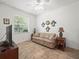 Living room features a comfortable sofa, stylish decor, tile floors and ample natural light at 4313 Heath Land Ln, Lake Wales, FL 33859
