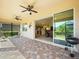 Covered patio with tile flooring, ceiling fans, sliding glass door to the interior, and a grill at 4313 Heath Land Ln, Lake Wales, FL 33859