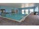 The indoor pool area features ample natural light, brick flooring, and clear water for year-round enjoyment at 4313 Heath Land Ln, Lake Wales, FL 33859