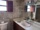 Bathroom features wallpaper, ample counter space with a sink, and window with wooden shutters at 460 Pinehurst Ct, Winter Haven, FL 33884