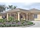 Welcoming exterior of a tan building with a covered entrance and well-maintained landscaping at 460 Pinehurst Ct, Winter Haven, FL 33884